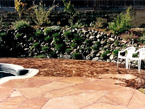 Pool Patio There is a spring present here. The wall placed on the 3/1 slopes keeps the hill in place. The redwood squares, beside the flagstone patio, have spaces between the wood, to allow water to pool and evaporate while allowing the squares to float, when the rain is heavy.